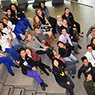 Group of people pose for photo on stairs.