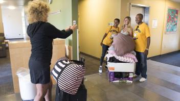 Laurie Meyers takes a photo of her daughter, Lainey Hauschildt, with LeShelle and Gary May as they help her move into her room in the Tercero Residence Halls on Saturday, September 23, 2017. Hauschhidlt is a freshman from Sebastopol, CA.