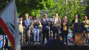Provost Ralph Hexter, LeShelle May and Chancellor May applaud the Cal Aggie Band-uh from the Grand Stand at Picnic Day. 