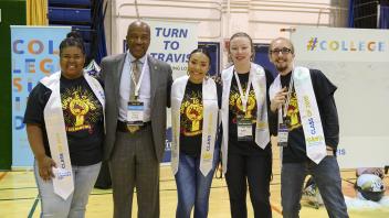 Seniors wear their graduations stoles flank Chancellor May as they pose for a photo during the Sacramento Area Youth Speaks and College Signing Day event in the Pavilion on May 3, 2019.  