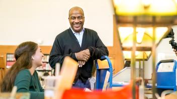 Chancellor May smiles and chats with a librarian at UC Davis. 