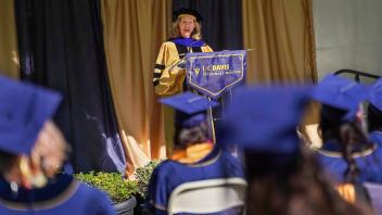 Provost Mary Croughan in commencement regalia speaking at a podium