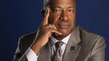 A portrait of Chancellor Gary May in front of a dark blue background