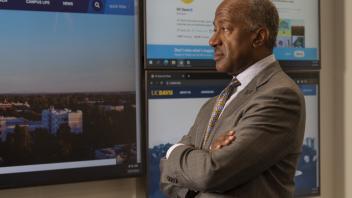 Chancellor Gary May looking a large display screen with information on it
