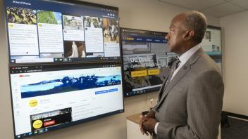 Chancellor Gary May looking a large display screen with information on it