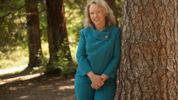 provost mary croughan poses at a tree