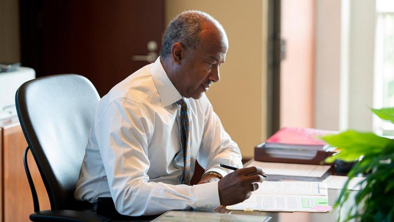 Chancellor May sitting at desk writing a letter
