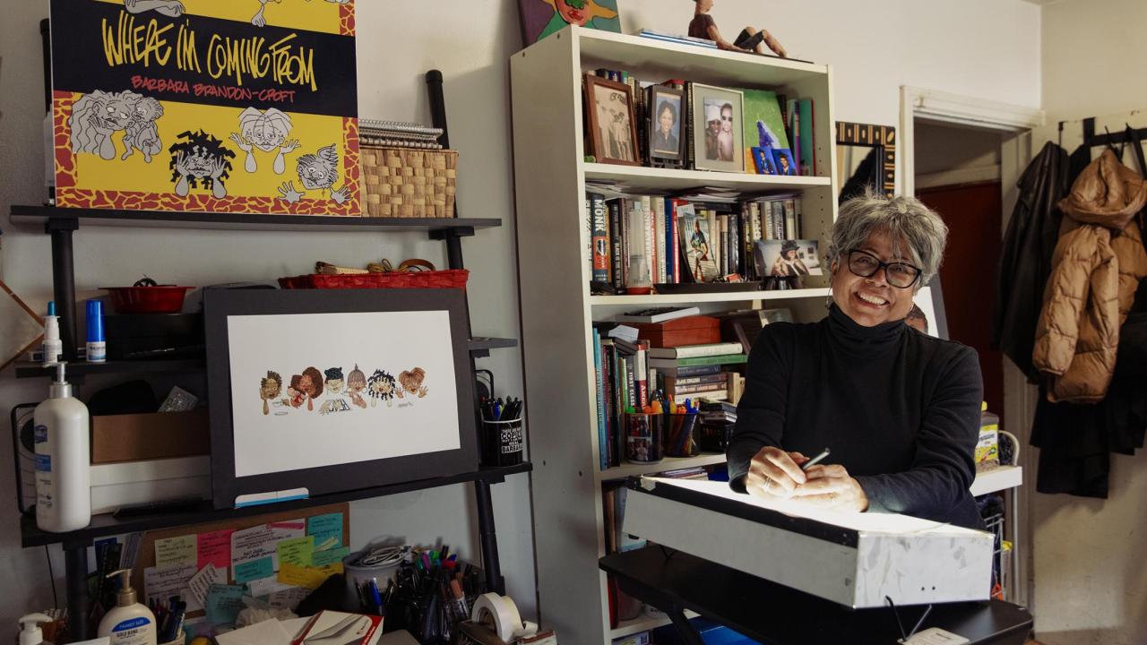 Barbara Brandon-Croft in her office surrounded by her illustrations.
