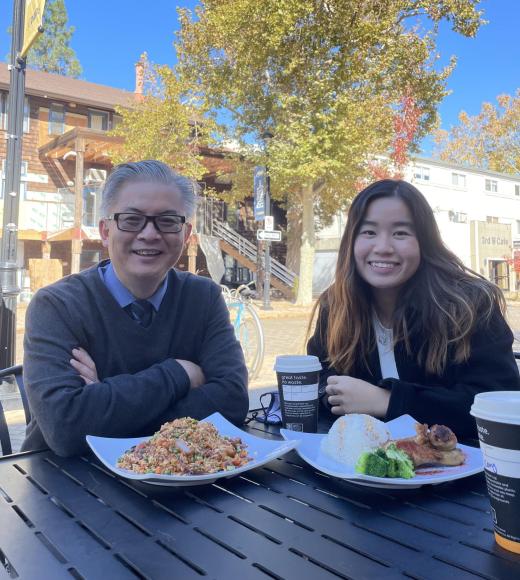 Two people sit at a table with lunch food in front of them