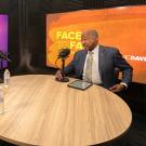 Chancellor May with two other people sitting at table in podcast studio.